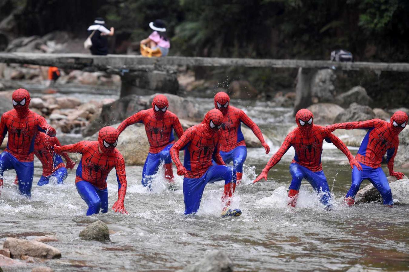 Participantes vestidos con trajes de Spiderman en un arroyo durante un evento en el Parque Nacional Forestal de Jiulongjiang en Chenzhou, China
