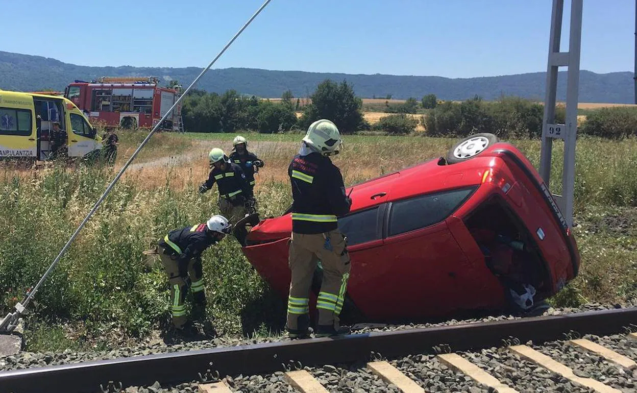 El coche ha quedado volcado junto a un poste de la catenaria que se ha doblado por el impacto. 