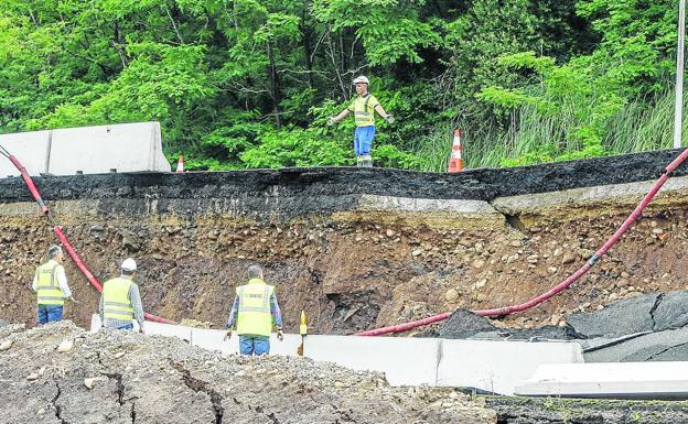 Cinco trabajadores de las constructora SIEC, que ayer comenzó la construcción de una escollera para estabilizar la zona, realizan labores sobre el terreno.