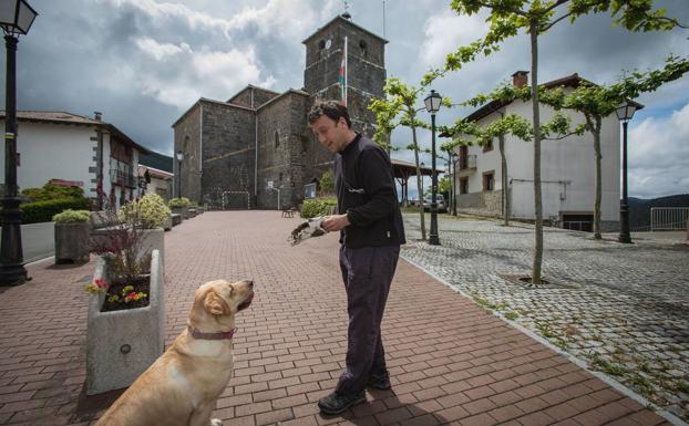 Ugaitz Oñarteetxebarria juega con Nala junto a la iglesia de Nabarniz.