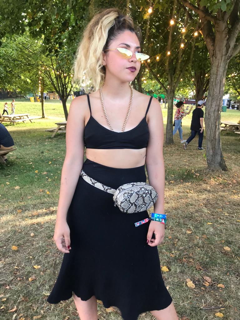 Claudia López visita el festival por primera vez con un look de estilo 'grunge' similar a los que lleva la artista catalana.El top es de Zara, el collar de eslabones dorados lo compró por Internet, la riñonera es de Pull & Bear y la falda de una tienda de segunda mano de la villa. Además, utiliza unas gafas de estética futurista que no faltan en el vestidor de Rosalía.i