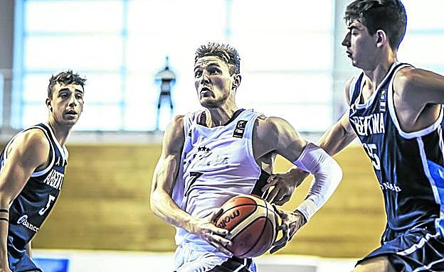 Arturs Kurucs se abre paso hacia el aro entre dos rivales durante un duelo del reciente Mundial sub'19. 