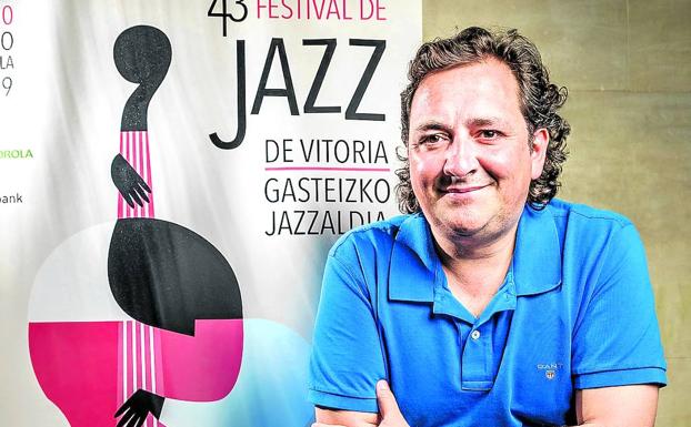 Íñigo Zárate, sentado ante un piano junto al cartel del 43 Festival de Jazz de Vitoria. 