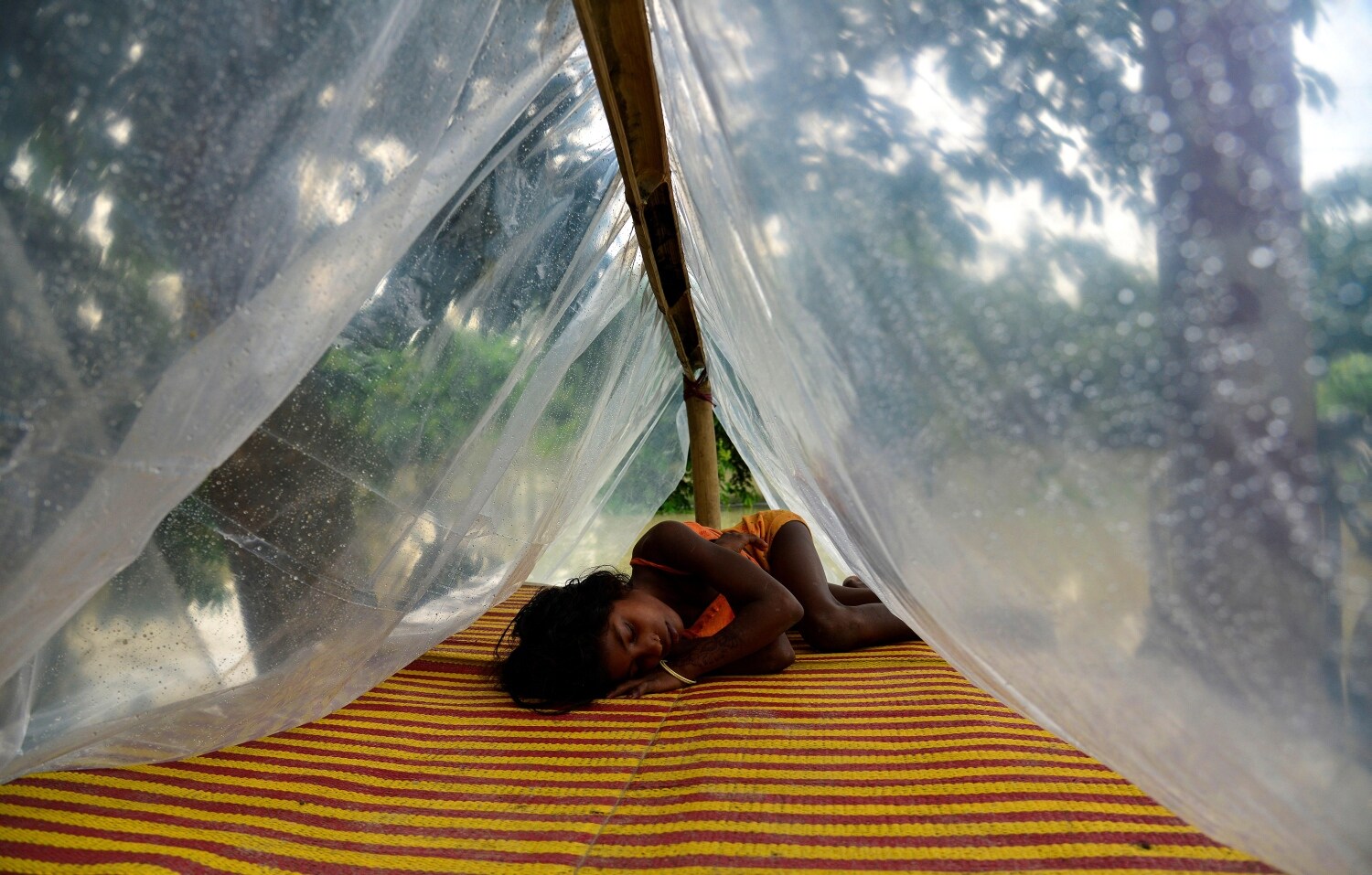 Una niña duerme en un campamento de ayuda en el distrito de Morigaon de Assam, India, afectado por la inundación. Según los informes de los medios, las inundaciones causadas por la lluvia del monzón han afectado a más de cuatrocientas mil personas en once distritos del estado de Assam.