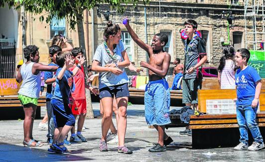 Niños participantes en las colonias de verano de Berakah juegan en la fuente de la plaza de Santa María.