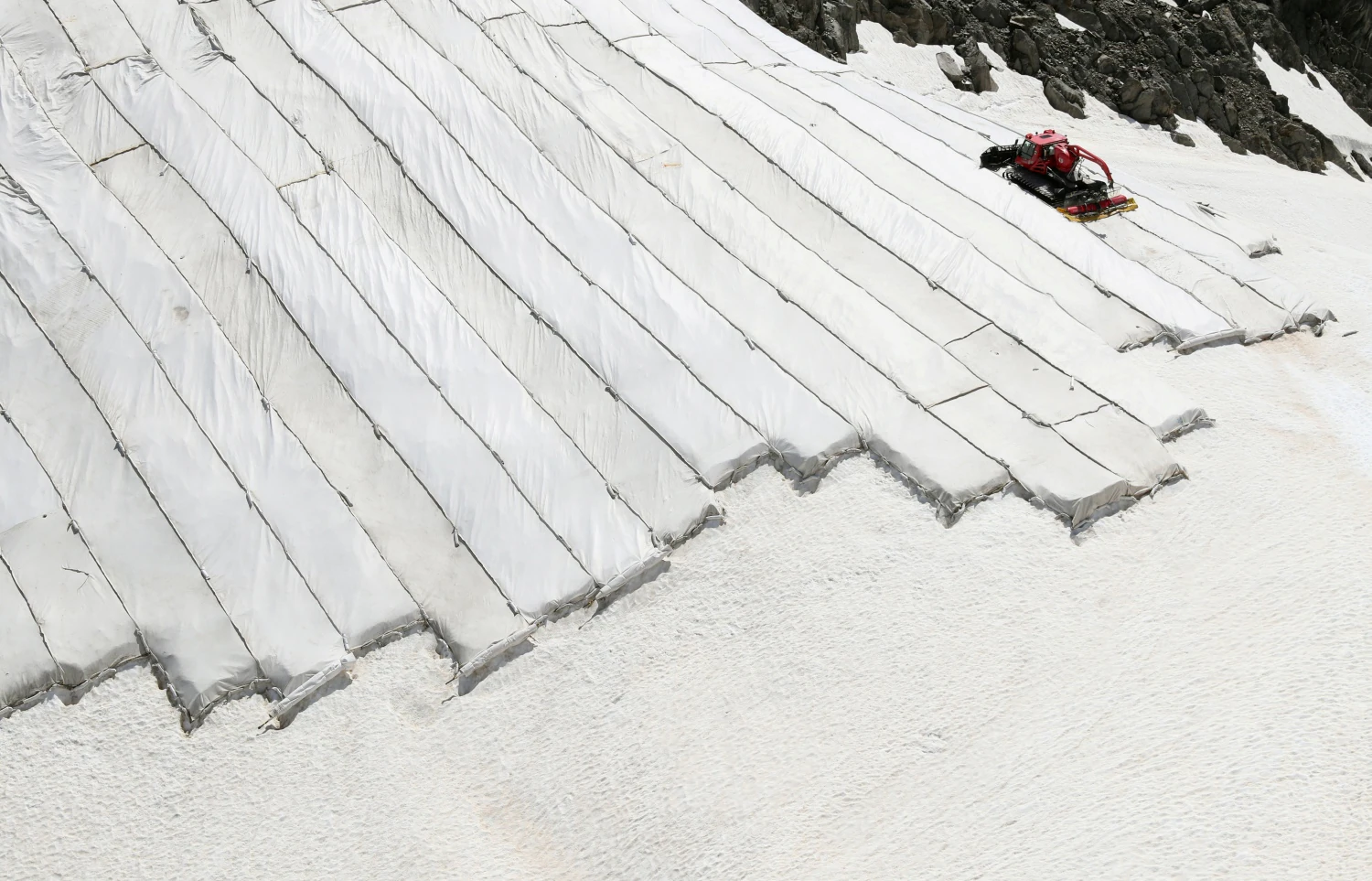 Partes del glaciar Gurschengletscher están cubiertas con lonas cerca del pico del Monte Gemsstock (2,961 m / 9,715 pies) en Andermatt, Suiza, para reducir el deshielo durante el verano.