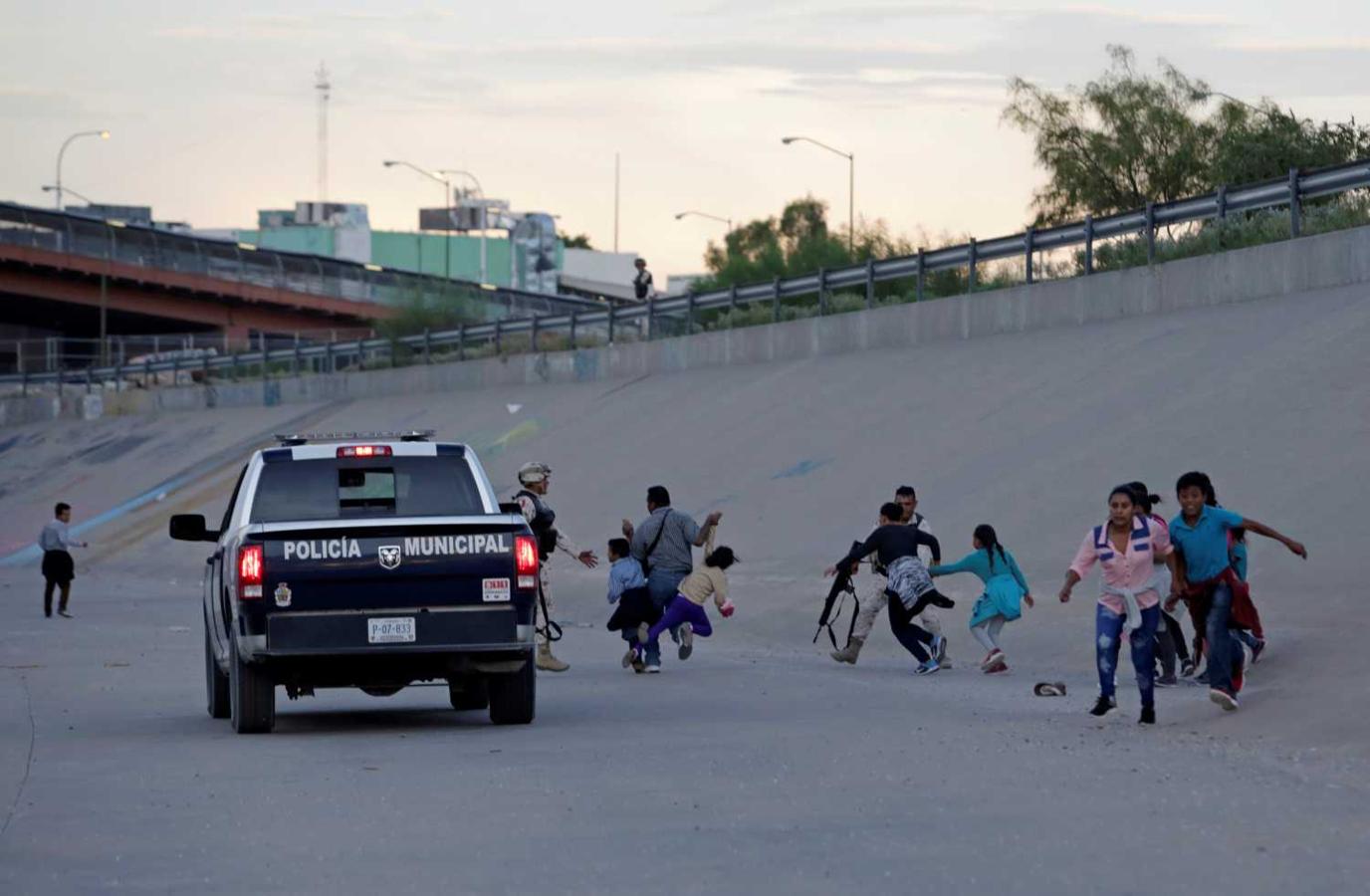Migrantes huyen de la policía municipal y miembros de la Guardia Nacional de México antes de cruzar ilegalmente a El Paso, Texas, (EE. UU