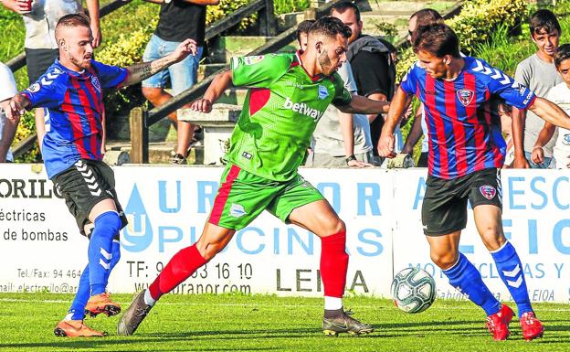 Luis Rioja, el único extremo puro de la primera plantilla, se zafa de dos rivales en el amistoso ante el Leioa.