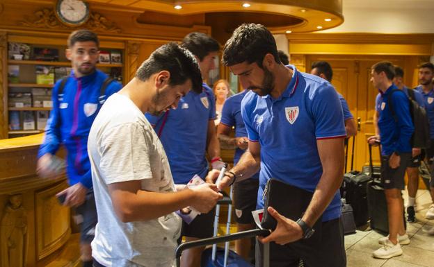 Raúl García firma un autógrafo a un aficionado a su llegada al hotel.