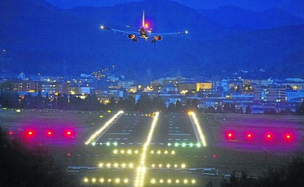 Un avión se dispone a aterrizar en la pista principal de Loiu en una noche de fuertes vientos.