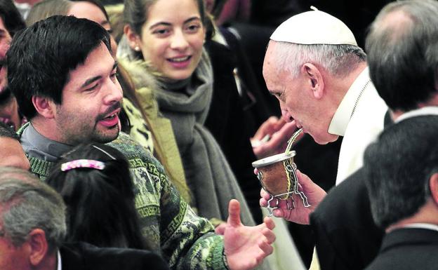 El Papa Francisco sorbe un mate ofrecido por unos compatriotas durante una audiencia general en el Vaticano. 