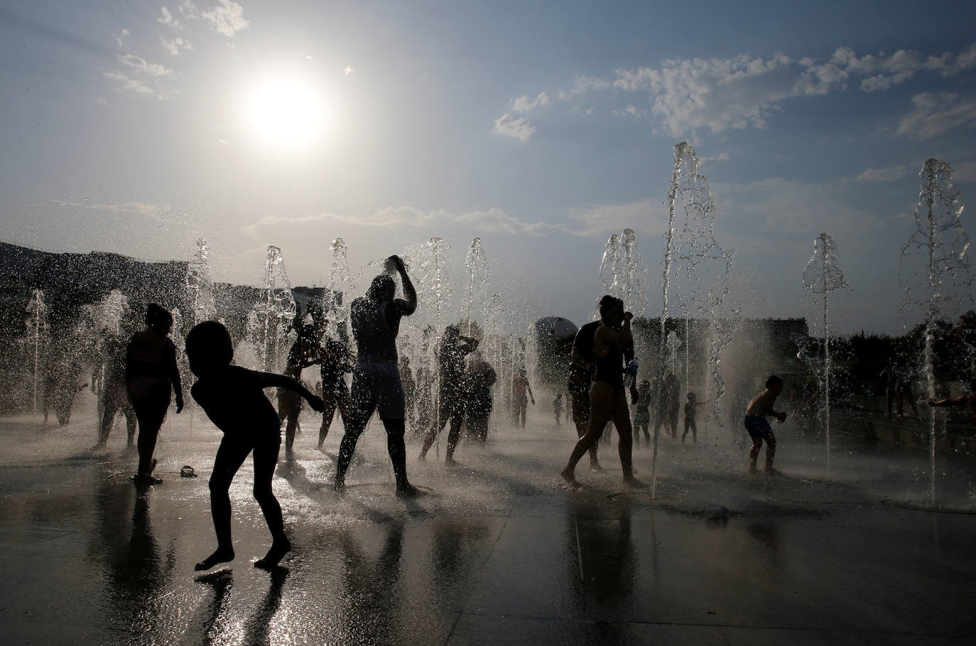Personas se refrescan en fuentes de París, en Francia. 