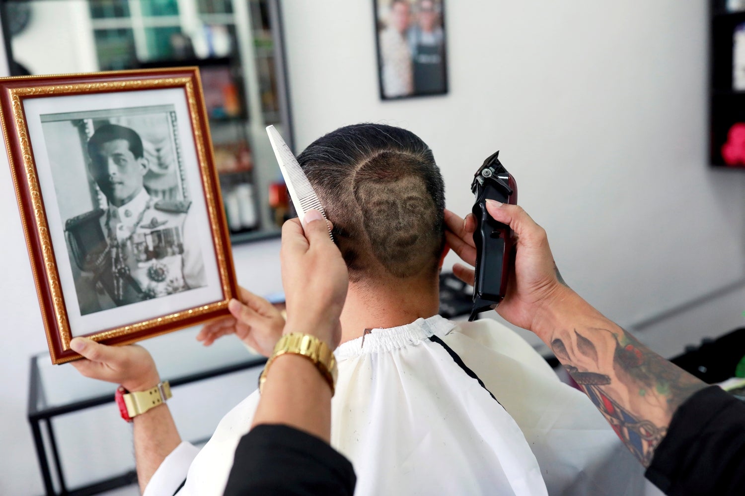 Mitree Chitinunda se corta el pelo formando una imagen que representa la cara del rey tailandés Maha Vajiralongkorn, para conmemorar el cumpleaños número 67 del rey, en una barbería en Bangkok, Tailandia