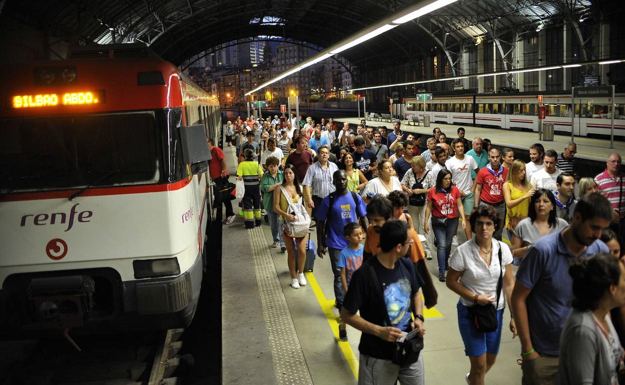 Un grupo de viajeros desciende de un tren de cercanías en Abando.