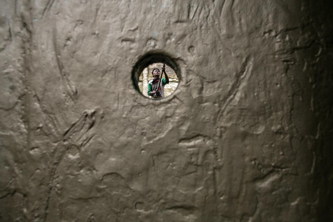 Un trabajador repara un barco en un astillero a orillas del río Yangon, ubicado en las afueras de Yangon