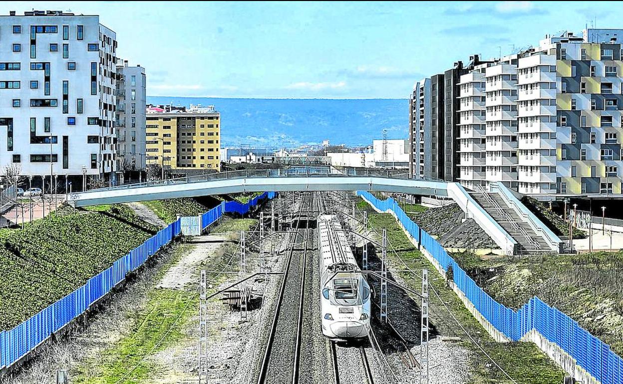 Un Alvia atraviesa Zabalgana por la vía ferroviaria, con los bloques de Margarita Neiken a su izquierda y Océano Pacífico a su derecha.