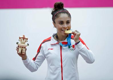 Imagen secundaria 1 - Arriba, Paola junto a su compañera de equipo Samantha Solas, con la que se llevó el oro en parejas. Abajo, celebrando una de las medallas y uno de sus tantos conseguidos en los partidos. 