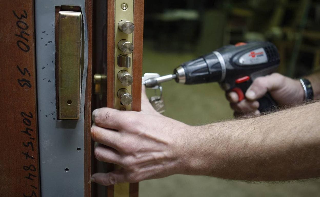 Un cerrajero arregla una puerta para evitar robos.