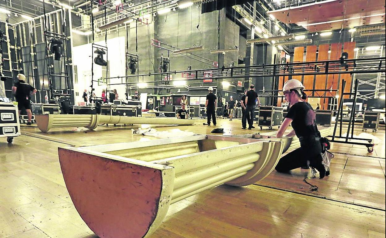 Varios empleados trabajan en el montaje del escenario. 