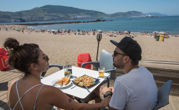 Una pareja disfruta del sol y la sombra en Arrigunaga.