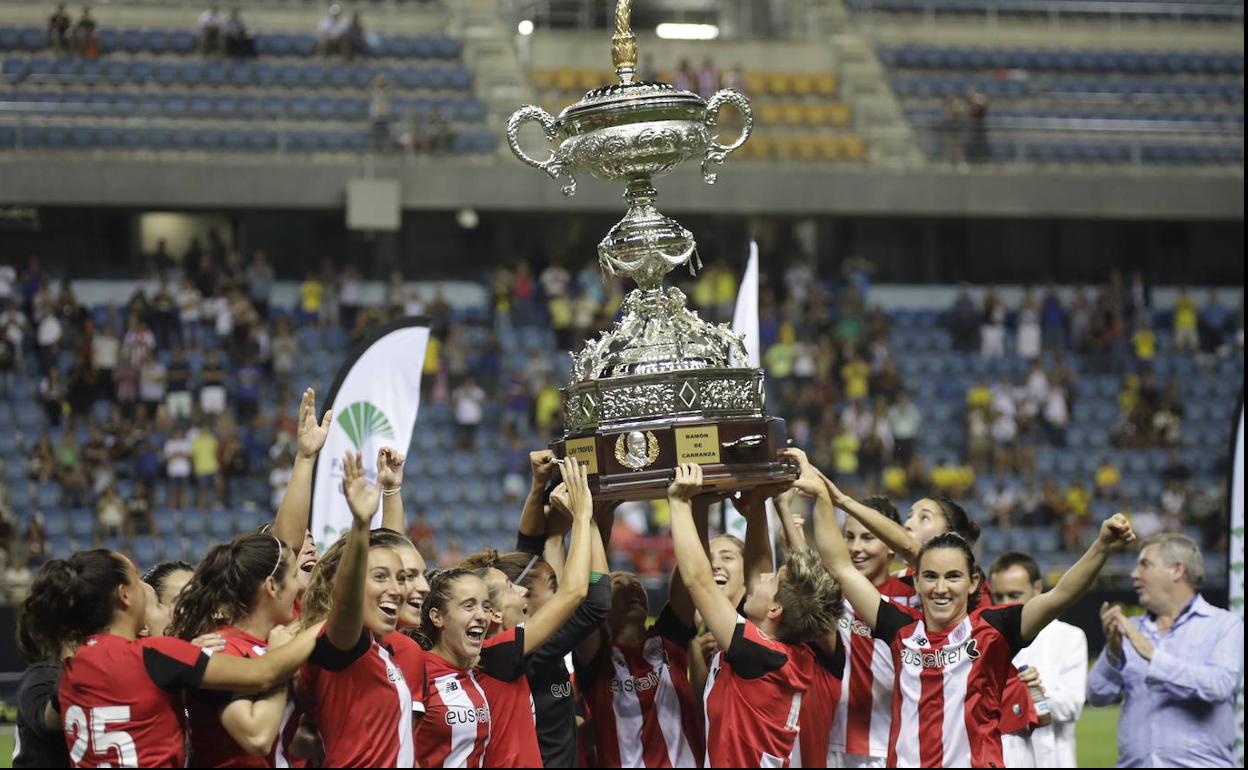 Las jugadoras alzan el trofeo.