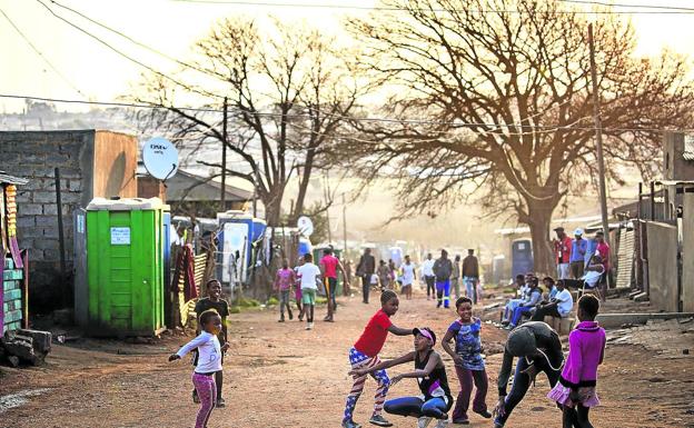 Niños juegan al atardecer en las calles de la barriadade Kliptown, en Soweto.