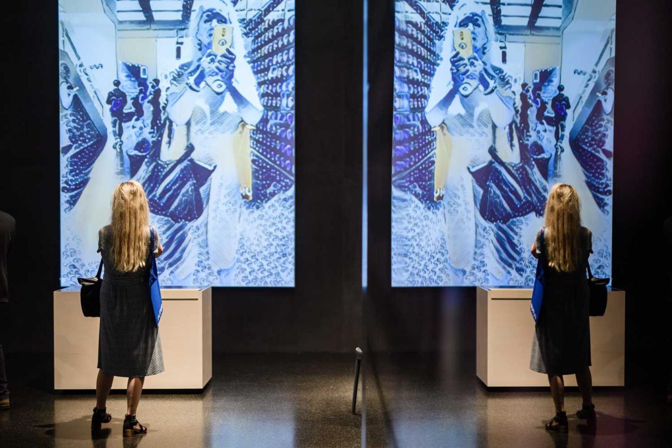 Una mujer observa una pantalla interactiva durante una exposición futurista en el edificio Futurium de Berlín 