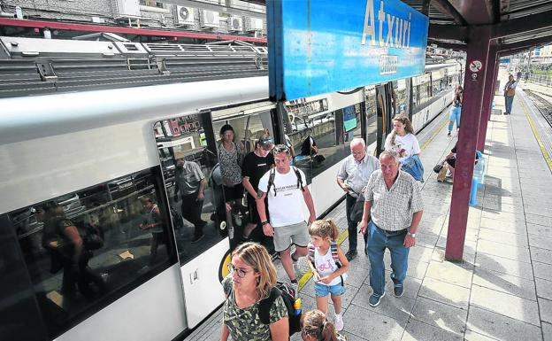 Un grupo de pasajeros de la línea de Bermeo desciende, ayer, del tren en la estación de Atxuri.