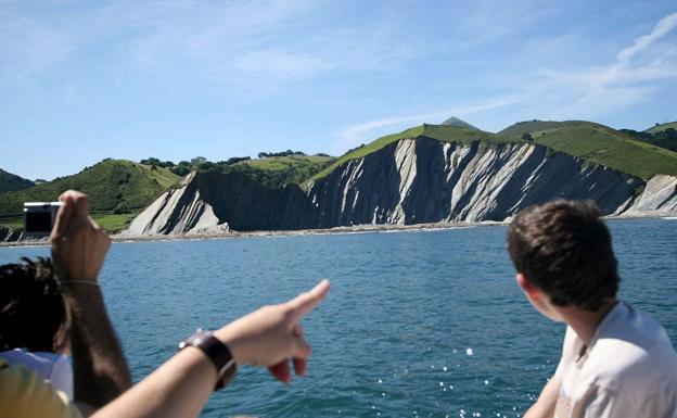 Los viajeros observan el flysch del litoral próximo a Zumaia.