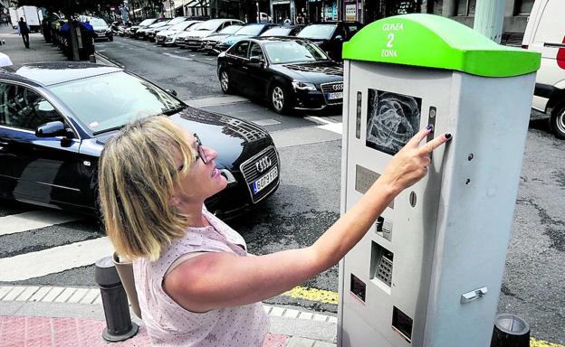 Una automovilista introduce los datos de su coche en la máquina de la OTA para validar su ticket de aparcamiento.