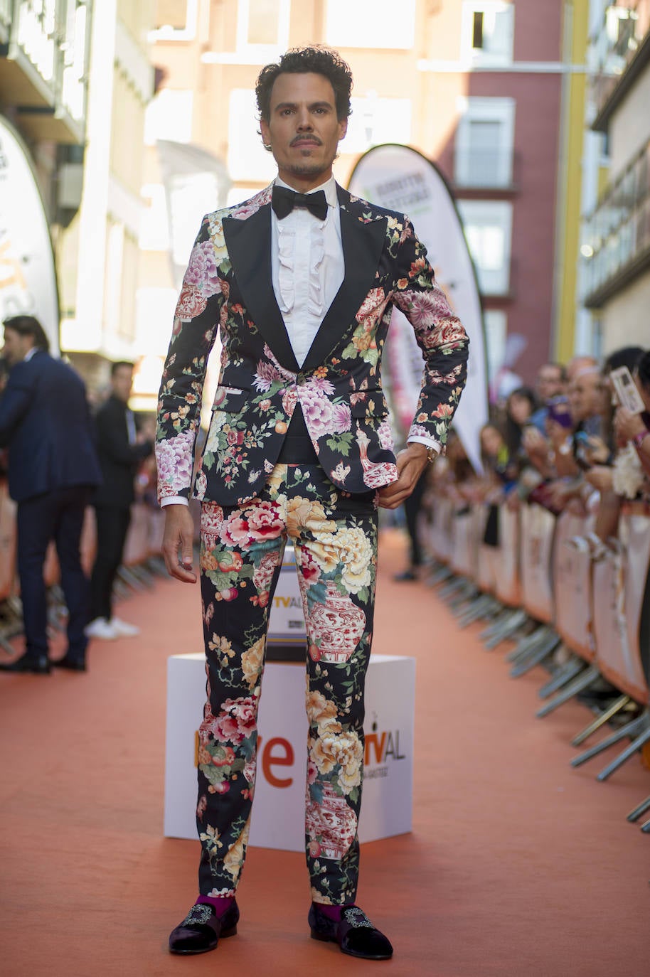 JUAN AVELLANEDA. El diseñador lució sin duda el estilismo más llamativo de la alfombra naranja. Optó por un colorido traje floreado confeccionado por el mismo combinado con una pajarita negra y camisa con chorreras. En los pies llevaba unos 'Manolos' de terciopelo con hebilla con pedrería que dejaban al descubierto unos llamativos calcetines rosa fucsia. Sus complementos tampoco pasaron desapercibidos: anillo de oro de compromiso, pulsera de oro y reloj Rolex.