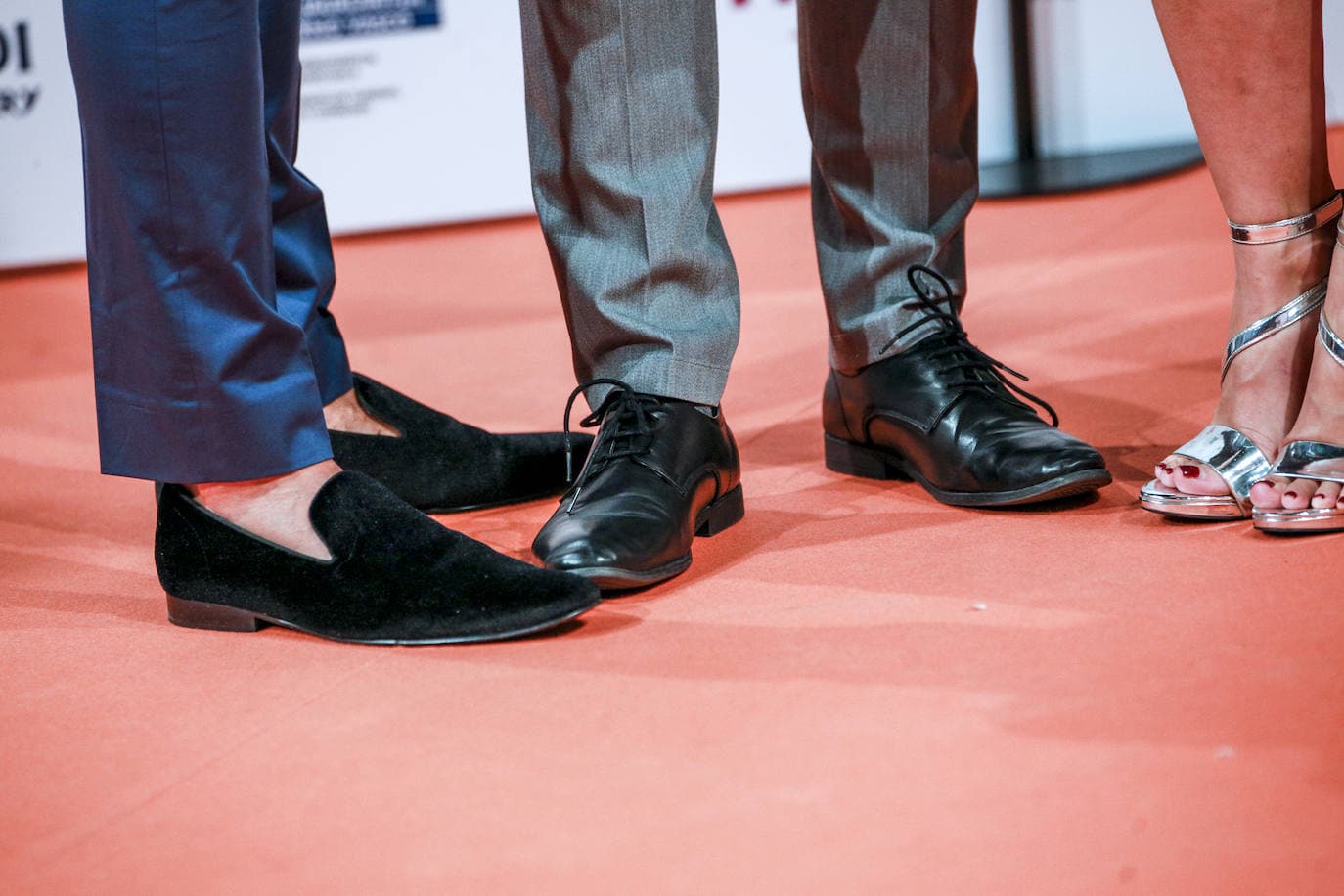 JUAN CABALLERO. El actor ha optada para la alfombra naranja por un traje de Zara gris que combinaba con camiseta negra, zapatos negros y un llamativo pendiente en plata de estilo trepador.