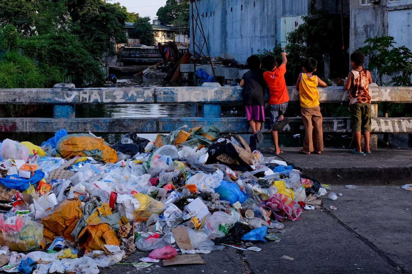 Montón de basura junto a los niños jugando en el centro de Manila