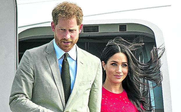 Enrique y Meghan bajan de un avión en uno de sus viajes. 