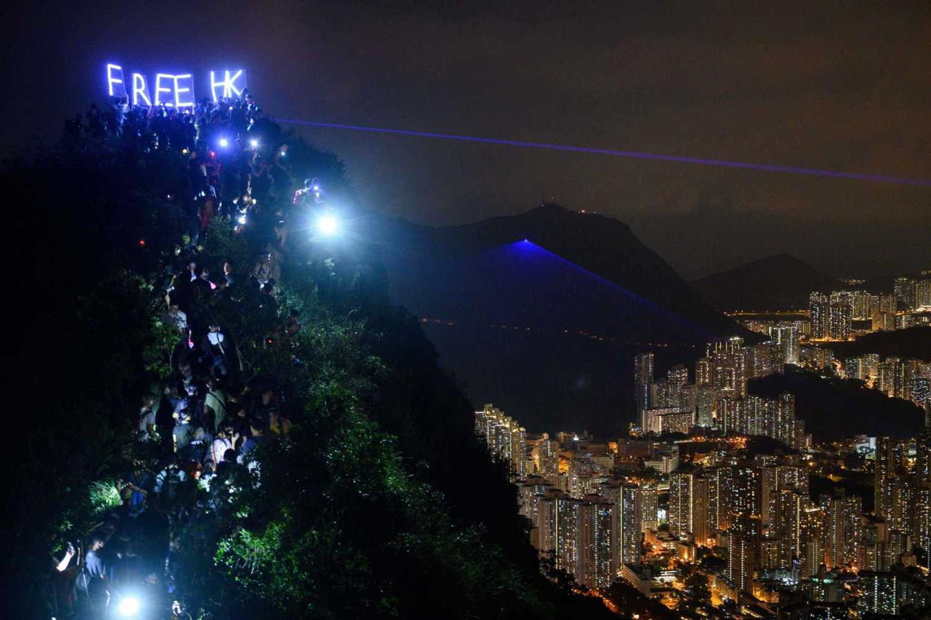 Activistas en favor de la democracia en Hong Kong iluminan con leds las palabras "Free HK" ("Hong Kong libre"), mientras forman una cadena humana en la Lion Rock que domina la ciudad