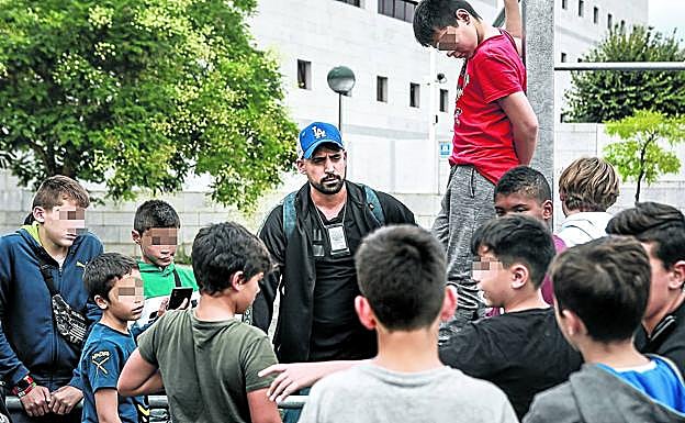 Rubén, responsable de la unidad de menores de la Policía Local, rodeado de chavalería en el parkour de Lakuabizkarra. 