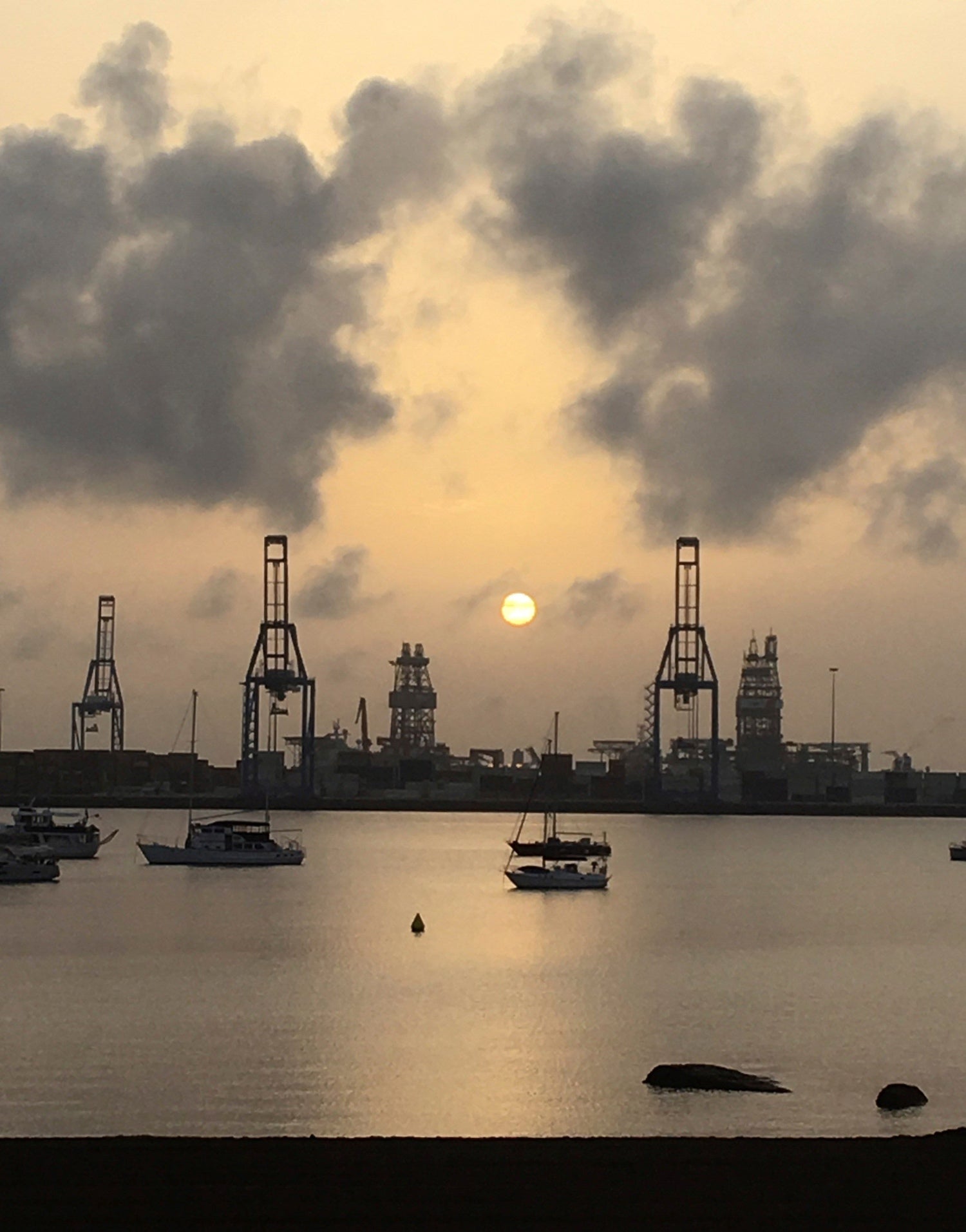 Amanecer de una jornada de calima (polvo del Sahara en suspensión en la atmósfera) en el puerto de Las Palmas de Gran Canaria, tras las tormentas que cayeron sobre la ciudad.