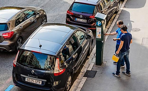 Un conductor extrae el tícket de OTA en una calle de Vitoria.
