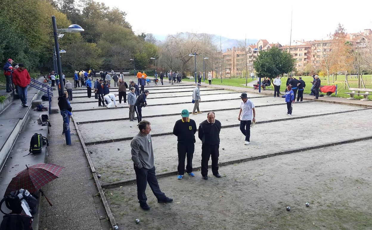 Grupos de personas jugando a la petanca. 