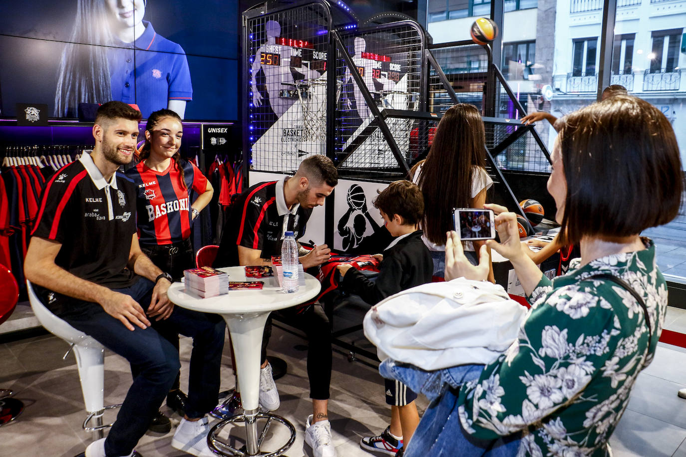 Encuentro con la afición. Los jugadores del Baskonia entraron uno a uno en la sede de General Álava tras saludar a los aficionados. Una vez dentro firmaron autógrafos y jugaron con los más pequeños en una sesión de puro hermanamiento baskonista