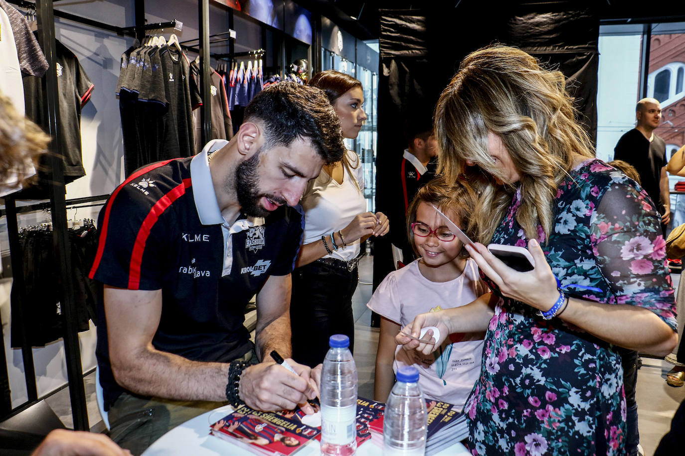 Encuentro con la afición. Los jugadores del Baskonia entraron uno a uno en la sede de General Álava tras saludar a los aficionados. Una vez dentro firmaron autógrafos y jugaron con los más pequeños en una sesión de puro hermanamiento baskonista