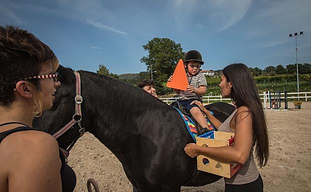 Imagen principal - Enaitz (4 años) y Mireia (14) disfrutan de la sesión de equinoterapia a lomos de 'Bagheera'