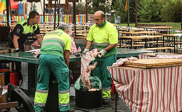 Personal municipal retira la carne del puesto clausurado. 