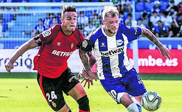 El albiazul John Gudeitti pugna en carrera con el defensa bermellón Valjent. 