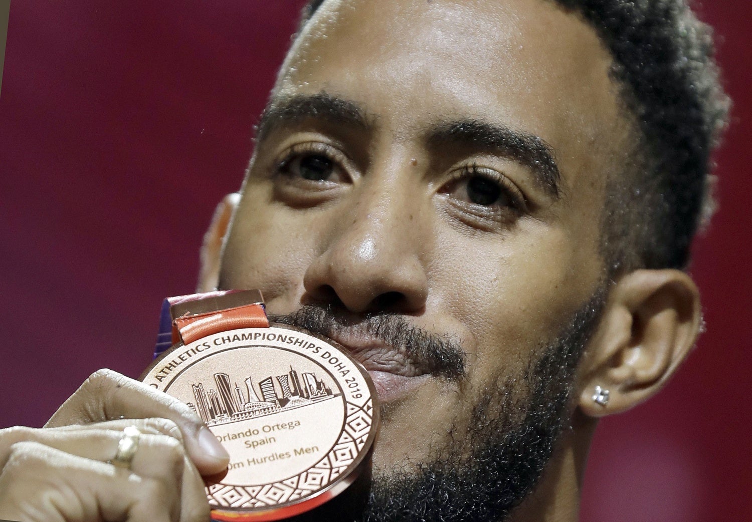 El atleta español Orlando Ortega besa la medalla de bronce en la ceremonia del podio de la final 110 metros vallas del mundial de Atletismo IAAF Doha 2019, en Catar. 