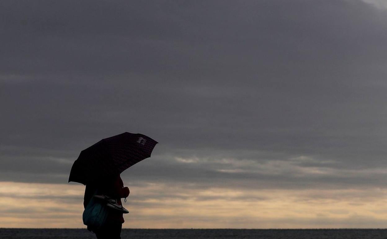 Un hombre se protege de la lluvia con su paragüas