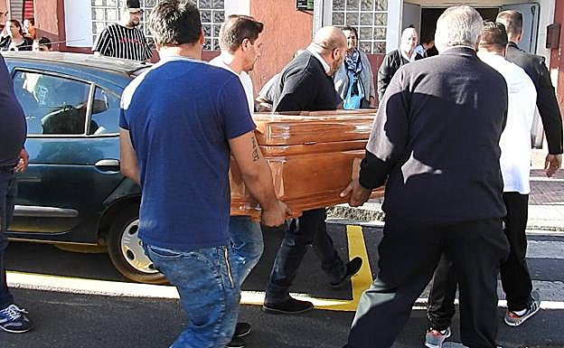 Familiares y amigos del fallecido portan su féretro.