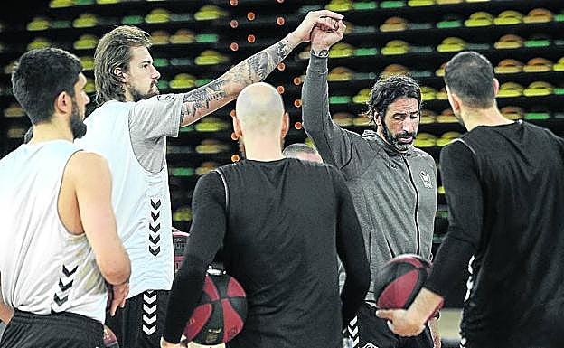 El pívot Balvin coge la mano de Alex Mumbrú, en el centro, durante un entrenamiento del RETAbet en el pabellón de Miribilla.