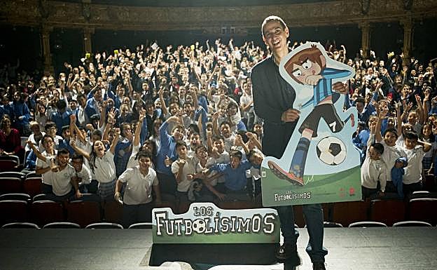 El escritor Roberto Santiago, autor de 'Los Futbolísimos', en el escenario del teatro Campos con quinientos chavales de colegios vizcaínos en el patio de butacas.
