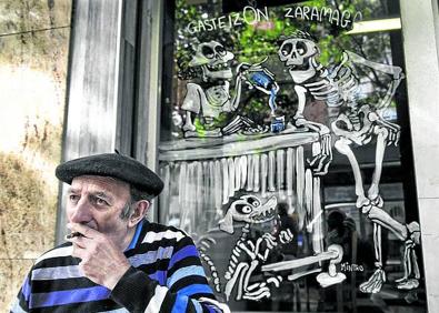 Imagen secundaria 1 - Arriba: Los disfraces más aterradores se dejarán ver esta noche por las calles de Vitoria. Abajo, a la izquierda: En la barra de un bar, de charla con unos 'amigos'. A la derecha: El esqueleto, con pan y jamón en otro comercio.